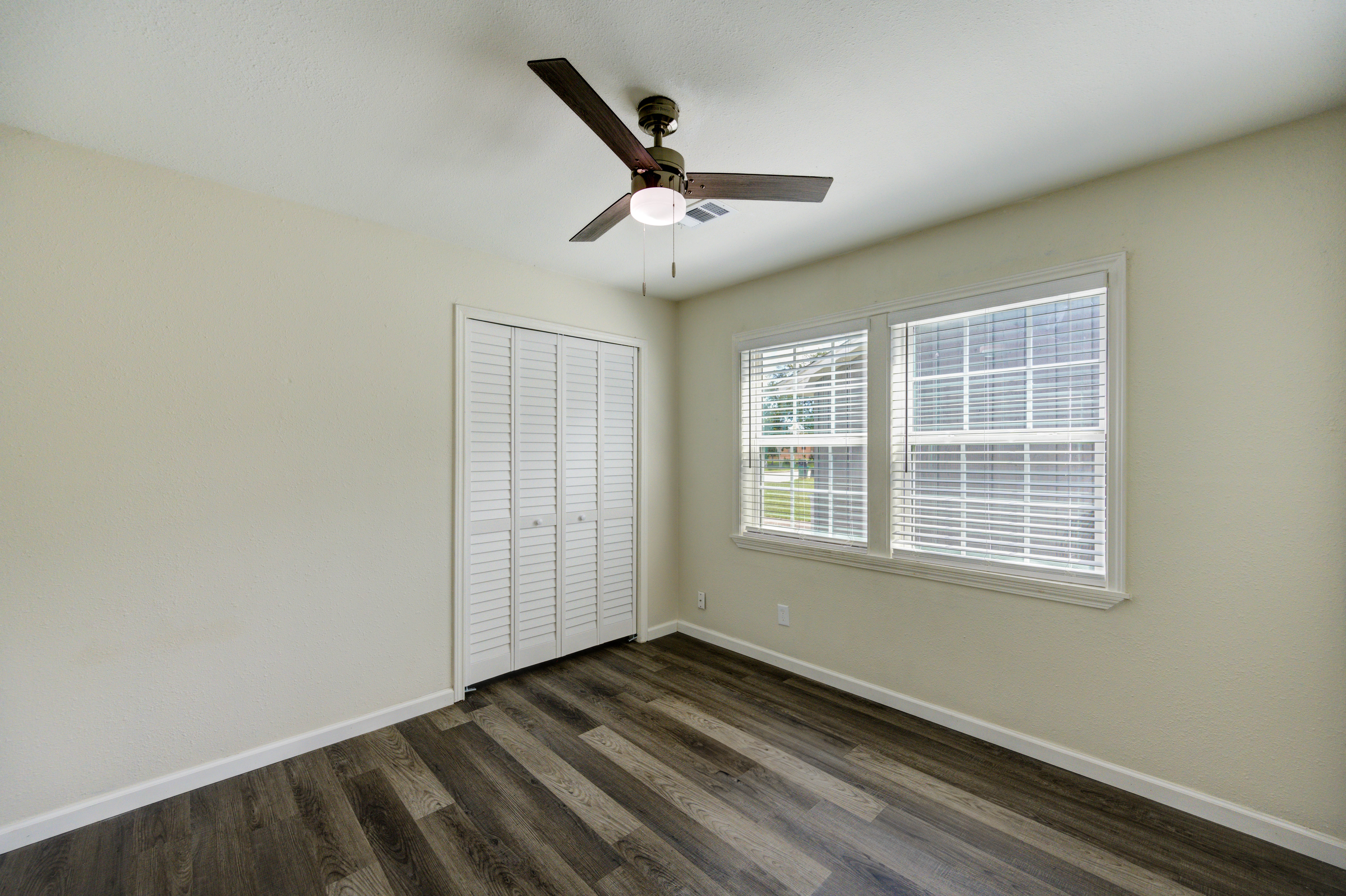 Bedroom with ceiling fan and closet