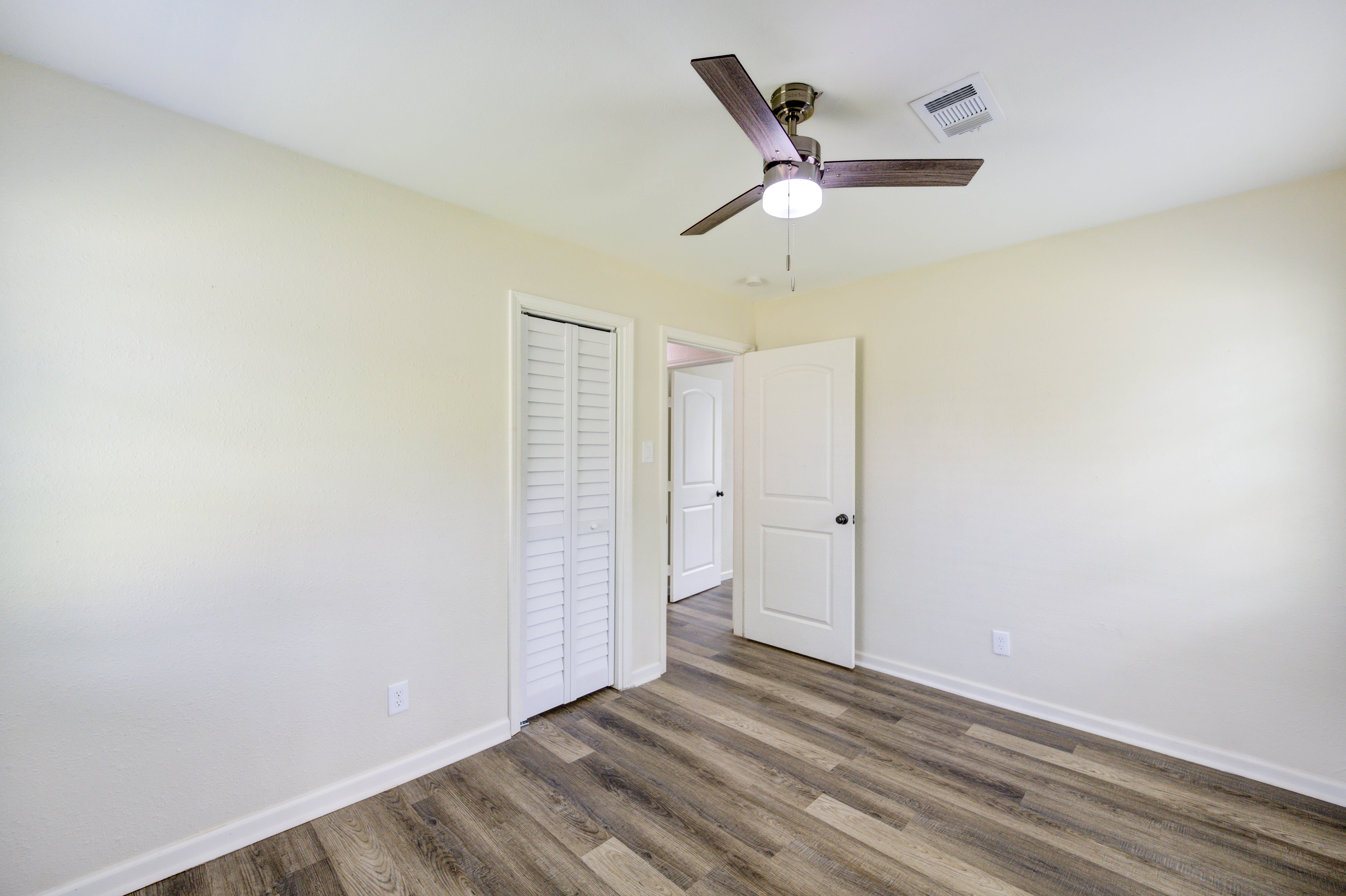 Bedroom with vinyl plank flooring and closet